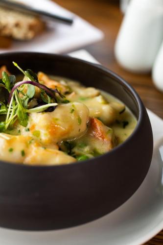 a black bowl of food on a white plate at The Lodges at Kilkea Castle in Kilkea