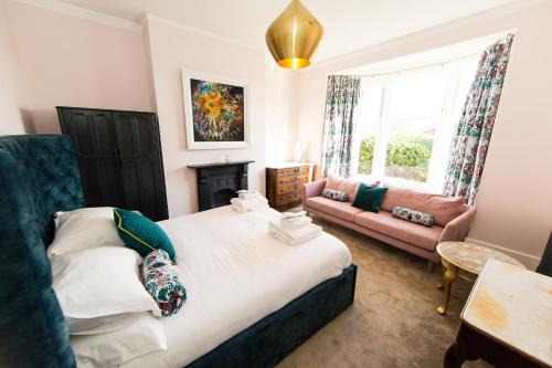 a bedroom with a large bed and a couch at Villa Neptune at Rounton Villa by Maison Parfaite - Hot Tub - Parking - Robin Hoods Bay in Robin Hood's Bay