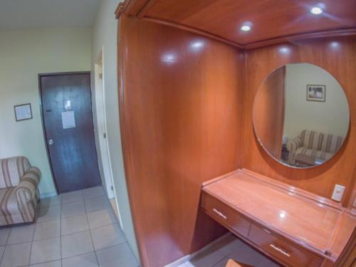 bagno con specchio e mobile con lavabo in legno. di Hotel Plaza Sahuayo a Sahuayo de José María Morelos