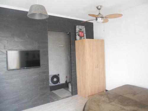 a bedroom with a flat screen tv on a brick wall at CosyStudio Site du Futuroscope in Chasseneuil-du-Poitou