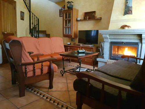 ein Wohnzimmer mit einem Sofa und einem Kamin in der Unterkunft Casa Rural con encanto en Las Arribes Abuelo Román in Masueco