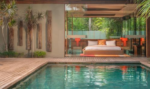 a bedroom with a bed and a swimming pool at iVilla by Ekosistem in Seminyak