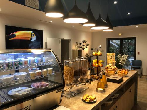 a bakery with a counter with food on it at Hotel Cantosorgue in LʼIsle-sur-la-Sorgue