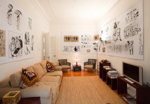 ein Wohnzimmer mit einem Sofa und einem TV in der Unterkunft Gulbenkian in Lissabon