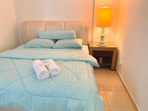 1 dormitorio con 1 cama con 2 toallas en SEA LA VIE @ LAGUNA CONDO RESORT, en Port Dickson