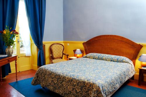 sypialnia z łóżkiem, stołem i krzesłem w obiekcie Hôtel Colombet w mieście Nyons