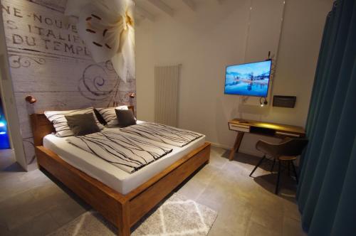a bedroom with a bed and a desk and a television at CityMotel Ziegenhain in Schwalmstadt