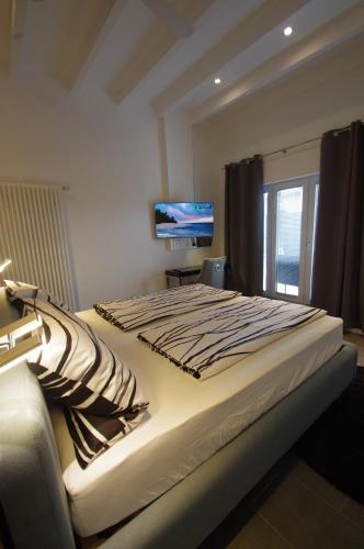 a bedroom with a large bed with a television on the wall at CityMotel Ziegenhain in Schwalmstadt