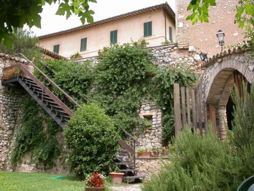 a stone building with a staircase in front of it at Agriturismo I Mandorli in Trevi