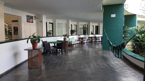 a lobby with tables and chairs in a building at Angra Inn, Angra dos Reis - Mar, Sol e Piscina in Angra dos Reis
