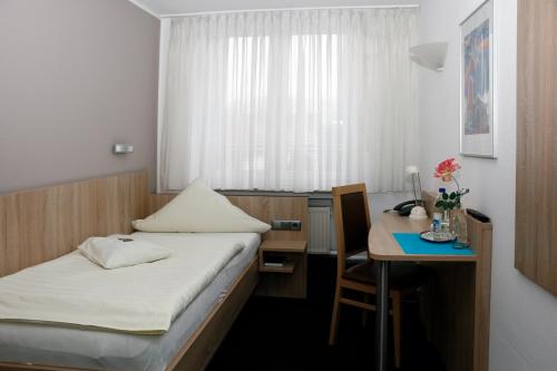 Camera piccola con letto e scrivania con tavolo di Hotel Restaurant Vogt a Rietberg