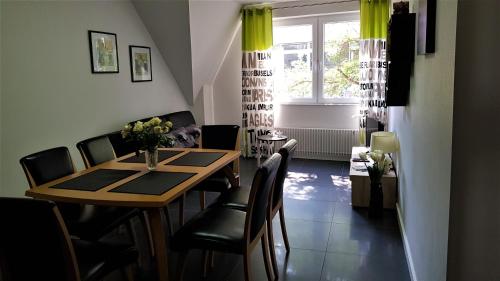 a dining room with a table and chairs and a window at Ferienwohnungen Hankenstraße in Bremen