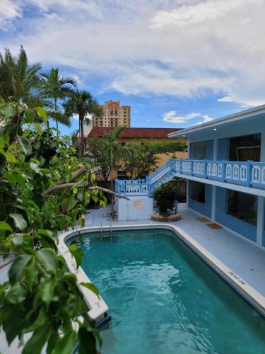 a swimming pool with a building in the background at Hotel Motel Lauderdale Inn in Fort Lauderdale