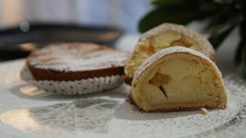 Zwei Muffins stehen mit Puderzucker auf einem Tisch. in der Unterkunft Elegance B&B in Neapel