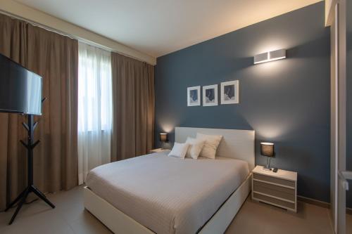 um quarto com uma cama e uma parede azul em ATMOSFERA APARTMENTS & SUITES em Borgaro Torinese