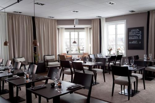 un restaurante con mesas, sillas y ventanas en Hotel Villan, en Gotemburgo