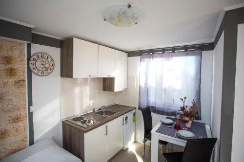 a small kitchen with a sink and a table at Apartments Vukman in Trogir