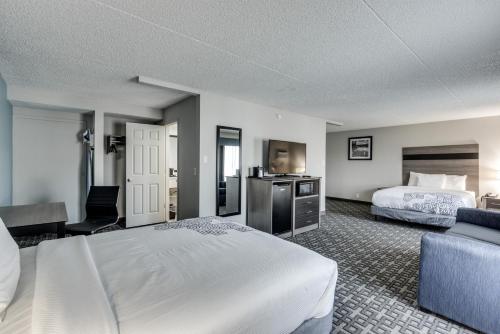 a hotel room with a bed and a couch at Days Inn & Suites by Wyndham Spokane in Spokane