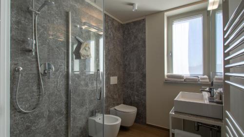 e bagno con doccia, servizi igienici e lavandino. di ATMOSFERA APARTMENTS & SUITES a Borgaro Torinese