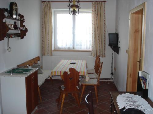a kitchen with a table and chairs and a window at Pension Otěvěk in Trhové Sviny