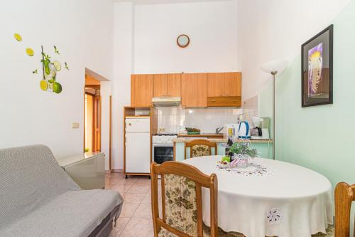 ein Wohnzimmer mit einem Tisch und einer Küche in der Unterkunft Apartment Buic in Pula