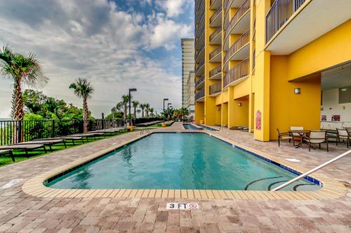 a swimming pool in front of a building at Hosteeva Beachfront Condo at Anderson Ocean Club in Myrtle Beach