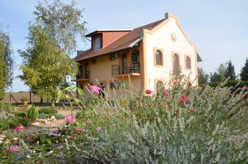 un jardín frente a una casa con flores en Garden Vendégház Makó, en Makó