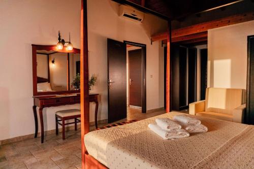a bedroom with a bed and a desk and a mirror at Natura Club Hotel & Spa - Adults Guests in Kyparissia