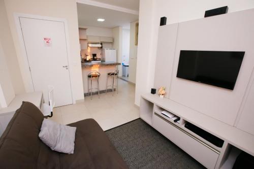 uma sala de estar com um sofá e uma televisão de ecrã plano em Flats Andira Kuss em Sinop