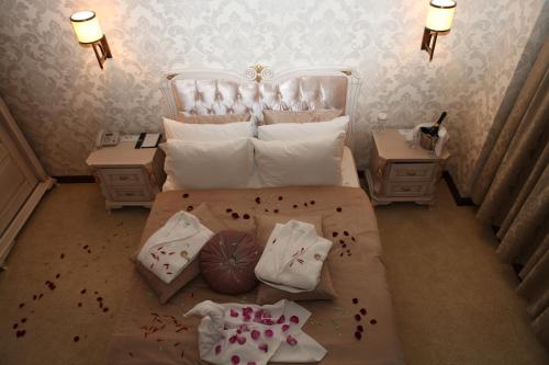 a bedroom with a bed with a white headboard and pillows at Vego Hotel in Ganja