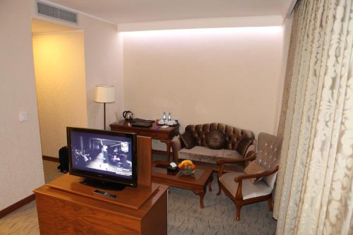 a living room with a couch and a television at Vego Hotel in Ganja