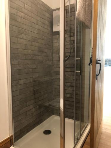 um chuveiro com uma caixa de vidro na casa de banho em Our Wendy House em Holsworthy