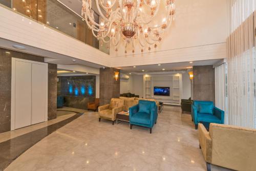 a lobby with blue chairs and a chandelier at Bisetun Hotel in Istanbul