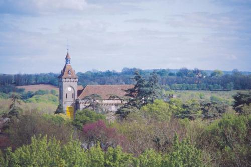 a building with a clock tower in the middle of a field at Hôtel Restaurant du Château in Rocamadour