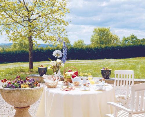 a table with a white table cloth and flowers on it at Hôtel Restaurant du Château in Rocamadour