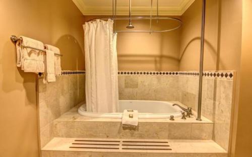 a bathroom with a bath tub with a shower curtain at Cottages and Suites at River Landing in Wallace