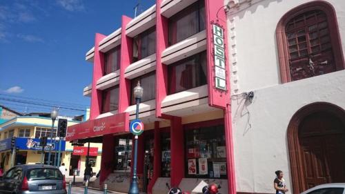 a red and white building on a city street at Flying Donkey in Otavalo