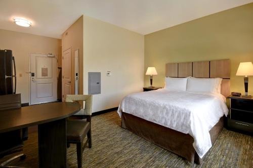 a hotel room with a bed and a desk and a desk at Candlewood Suites St Clairsville Wheeling Area by IHG in Saint Clairsville