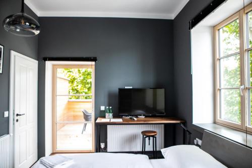 BruckneudorfにあるHotel Restaurant Josephの黒い壁のベッドルーム(テレビ、ベッド付)