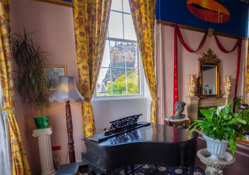 a room with a piano and a window at Castle Rock Hostel in Edinburgh