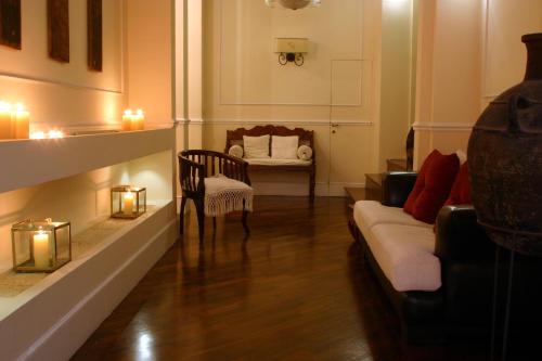 a living room with a couch and a chair and candles at Hotel Metropolitan in Bologna