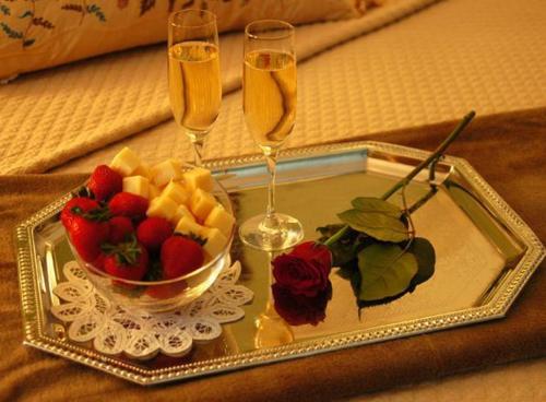 a tray with a bowl of fruit and two champagne glasses at Planters Inn on Reynolds Square in Savannah