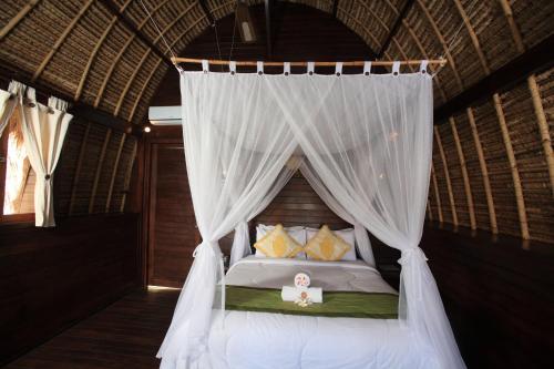 a bedroom with a bed with a canopy at Sunset Coin Lembongan in Nusa Lembongan