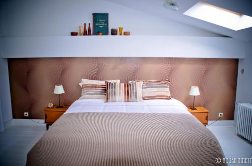 a bedroom with a large bed with two lamps at B&B House Ninety in Brussels
