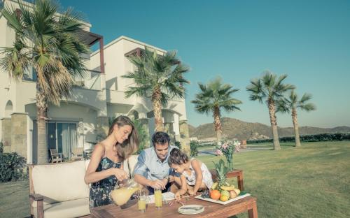 a family is sitting at a table with a picnic table at Xanadu Island in Akyarlar