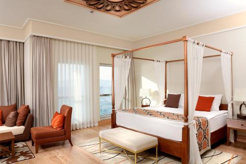 a bedroom with a four poster bed and a couch at Xanadu Island in Akyarlar