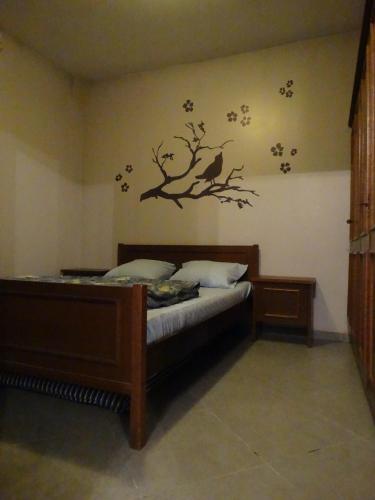 a bedroom with a bed with a bird sticker on the wall at Gîte Le Randonneur in Daverdisse