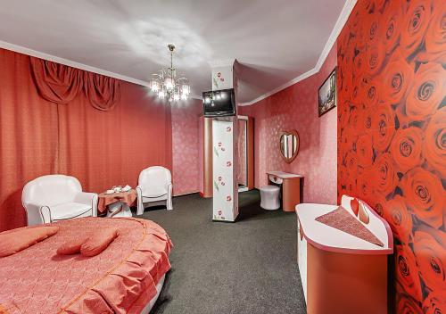 a hotel room with a bed, table, lamps and a window at Venecia Hotel & SPA in Zaporozhye