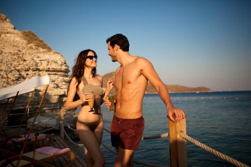 a man and a woman standing on a boat in the water at Xanadu Island in Akyarlar
