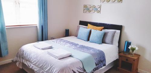 1 dormitorio con 1 cama grande con almohadas en Sun Gardens Serviced Apartment, en Thornaby on Tees